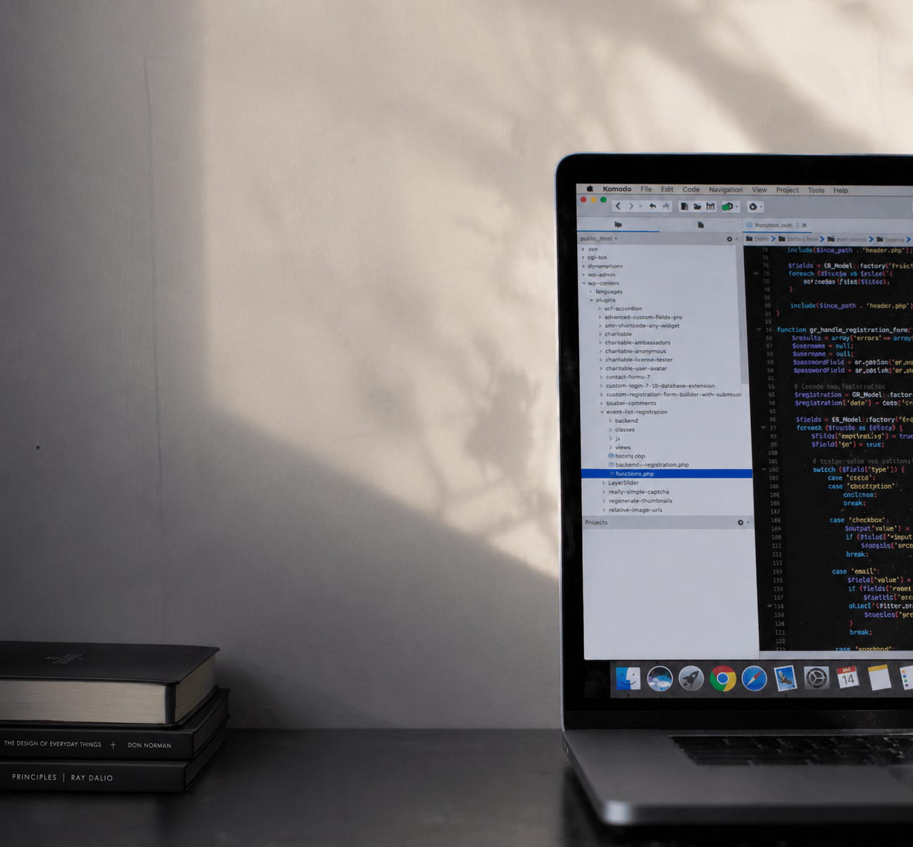 Laptop displaying source code on a sunlit desk